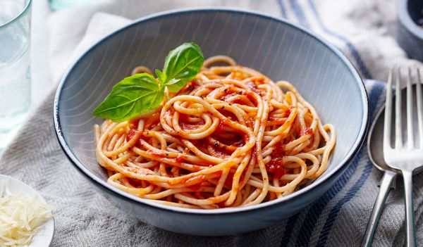 Соус для спагетти из томатной пасты закипит, влейте две столовые ложки